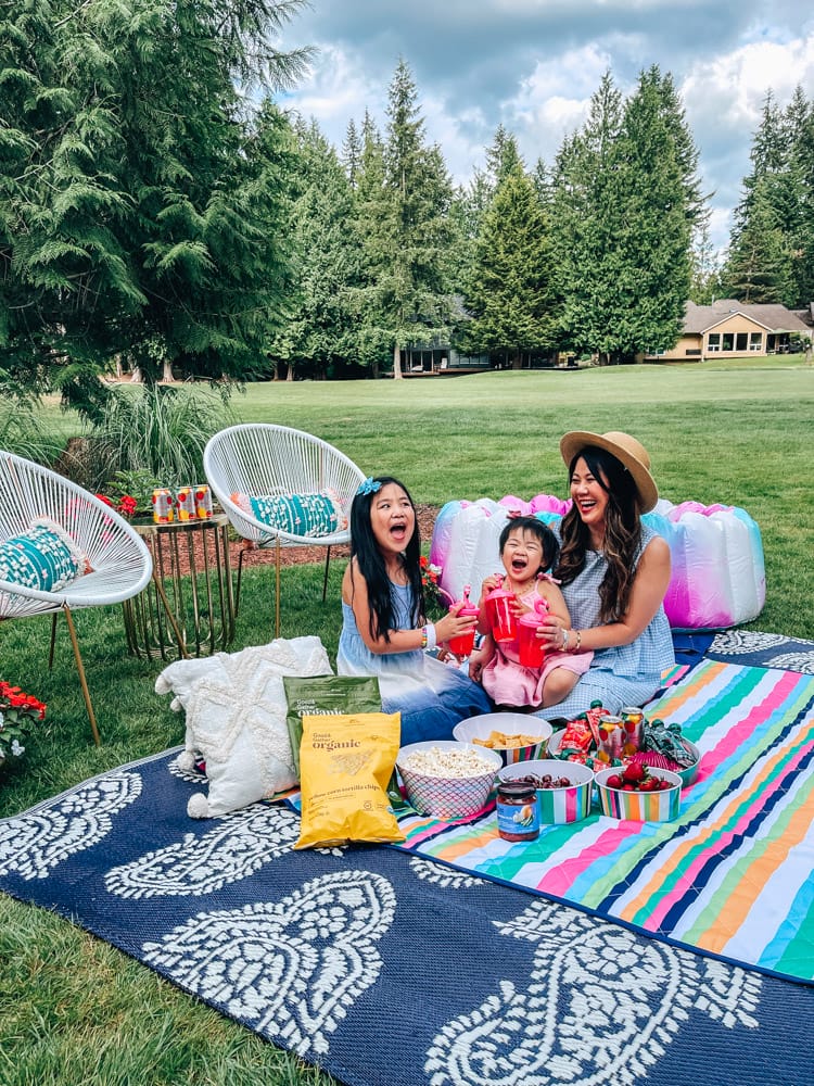 mom and daughters enjoying a backyard picnic
