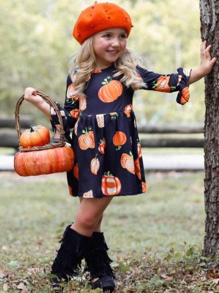 toddler girl in pumpkin dress and boots