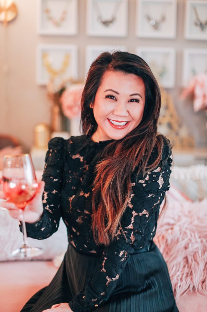 Woman wearing lace top and holding a wine glass