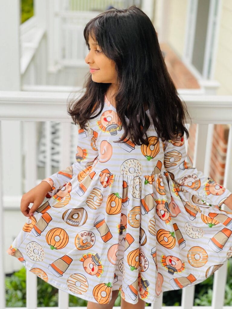 young girl wearing thanksgiving donut theme dress